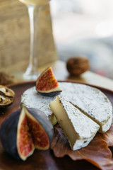 Handmade camembert cheese in herbs and figs