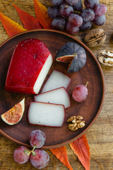 Handmade sliced gouda cheese in herbs and figs