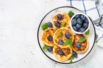 Cottage cheese pancakes on white table.