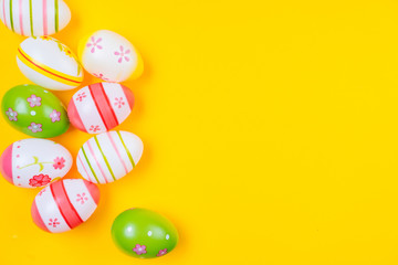 Colorful easter painted eggs background on yellow pastel color  background with space. Easter holiday concept. Traditional decoration for  springtime holiday. Top view easter greeting card