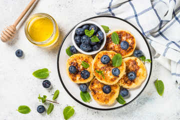 Cottage cheese pancakes on white table.