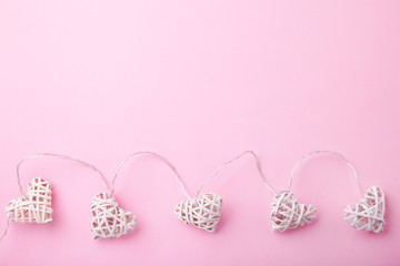 Valentines day greeting card. White garland of hearts on pink background.