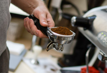 Barista prepares coffee, the process of making coffee in the cafe, the hands of the Barista close-up