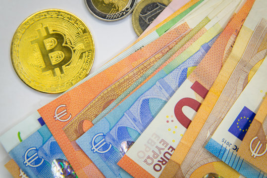 Golden Bitcoins close-up on euro currency background. High resolution photo