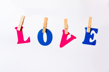 Clothes pegs and I LOVE YOU words on papers on rope on white background Valentines day concept