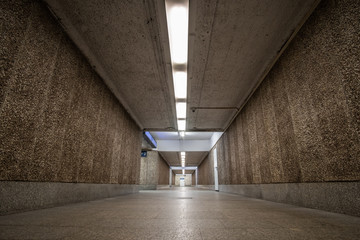 Old empty underpass with brown stone walls.