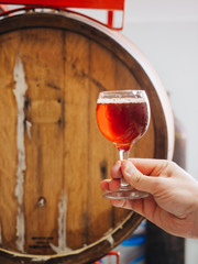 Glass with dark beer with wooden barrel