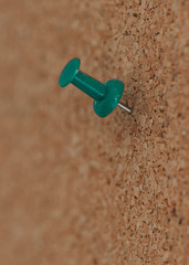 green pushpin on a cork board