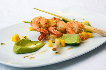 fried shrimps with vegetables and sauce on a white plate