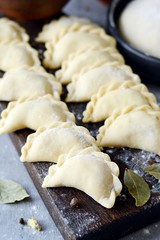Dumplings with potatoes with herbs on a blue background. Varenyky, vareniki, pierogi, pyrohy - dumplings with filling.