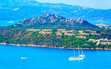 Obraz premium Landscape and scenery of Golfo Aranci atSardegna island in Italy in summer. Sassari province near Olbia and Cagliari. In Mediteranean sea. Yachts, boats and ships. Mixed media.