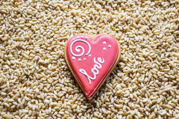 Heart-shaped cookies decorated with the word love on a wheat background. Valentine's day.