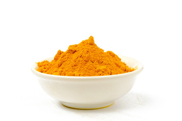 Turmeric powder in a bowl isolated white background.Close-up of powder orange color turmeric.
