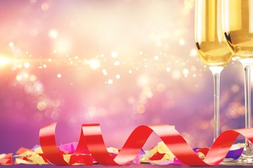 Glasses of champagne with curly ribbon on abstract background