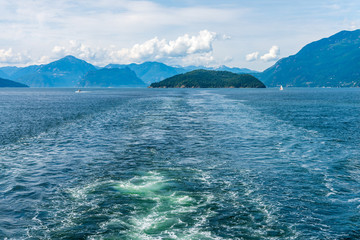 View over inlet, ocean and island with boat and mountains in beautiful British Columbia. Canada.