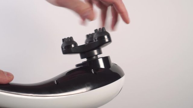Unscrewing the relief nozzle of the vibratory massager in black and white. Selection of individual massage equipment