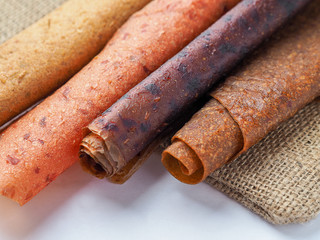 Colorful fruit leather rolls on white background
