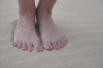Women's feet on the beach near the sea. The girl took a picture of his feet on the background of...