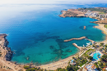 Fototapeta na wymiar Summer vacation in Cyprus island. Aerial view of bay with clear blue sea water and seaside with sand beach.