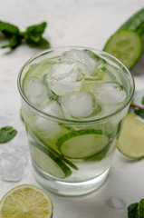 Infused water on a glass. Detox water mix of cucumber, lemon, lime and mint.