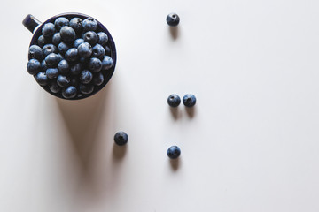 Blueberry explosion. Photo of blueberry in cup on white table. Top view. Healthy food, health