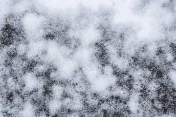 Fresh wet snow on asphalt driveway, as a nature background