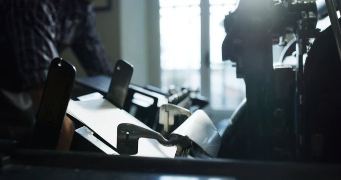 Slow motion close up of an antique ink printer is working on high quality handmade paper in an artisan paper making workshop. Shot in 8K. Concept of handmade,high quality,artisan, made 