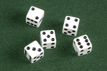 Four Individual white dice on green card table surface