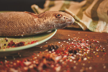 Fresh sea fish over green plate