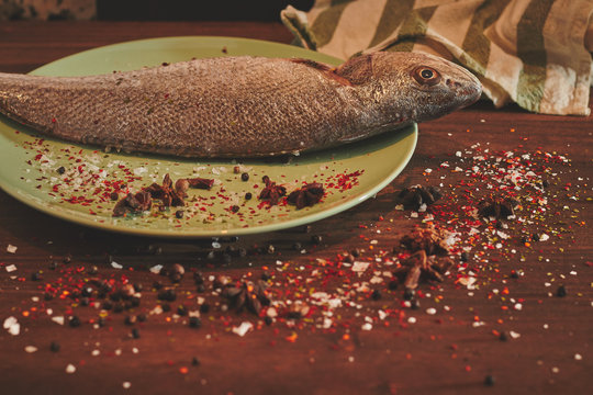 Fresh sea fish over green plate