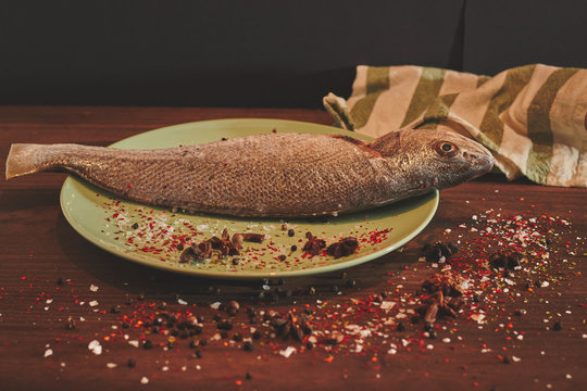 Fresh sea fish over green plate