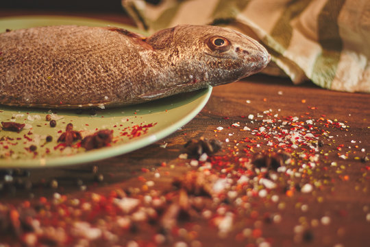Fresh sea fish over green plate
