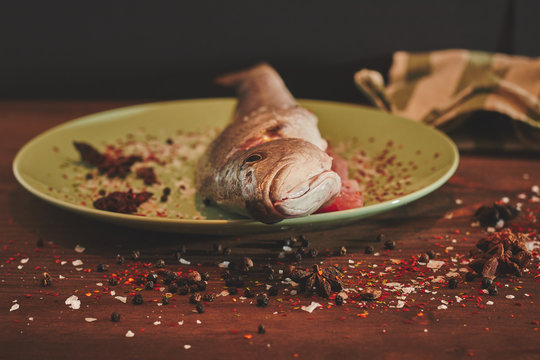 Fresh sea fish over green plate