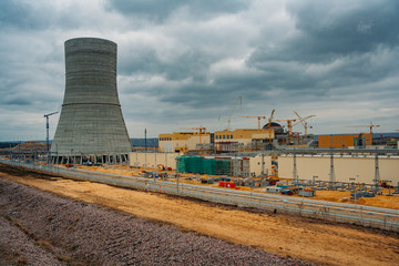 Construction site of new nuclear power plant on cloudy sky background