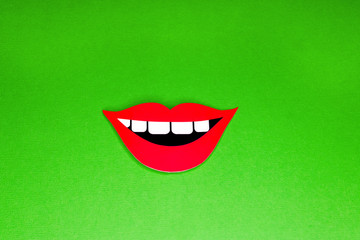 Red lips smile with white teeth on green background