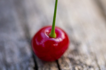 Red juicy cherry close-up. Falling from tree cherry on old wooden background.