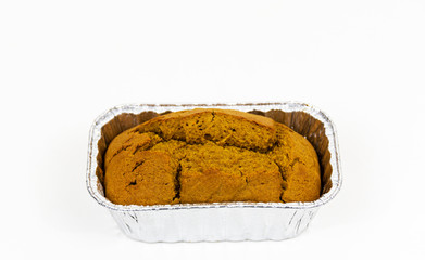 One loaf of pumpkin bread in a siver tin with a white background