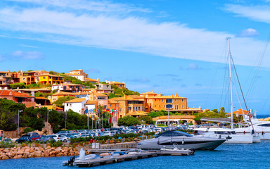 Fototapeta na wymiar Scenery with Marina and luxury yachts at Mediterranean Sea of Porto Cervo in Sardinia Island of Italy in summer. Landscape View on Sardinian town port with ships and boats in Sardegna. Mixed media.