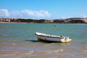 Fototapeta na wymiar A small white boat left anchored in Lake Magic in Western Australia