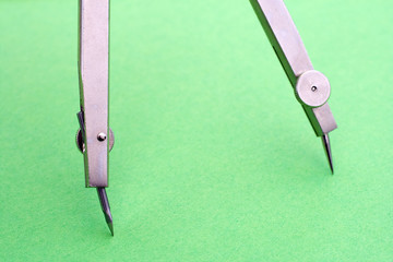 Drawing compass on a green background.