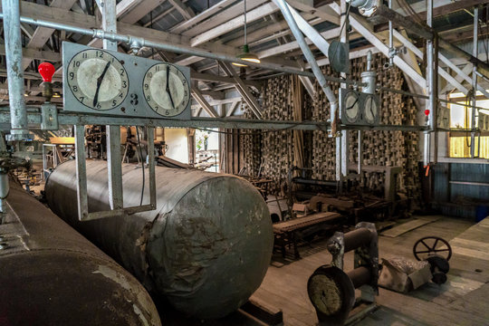 Old abandoned cannery. Two clocks are in the empty factory.