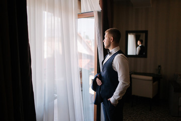 Handsome young groom dressed at hotel. Morning in hotel