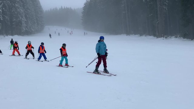 A ski school group of children and a teacher