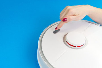 robot vacuum cleaner isolated on blue background, close up photo