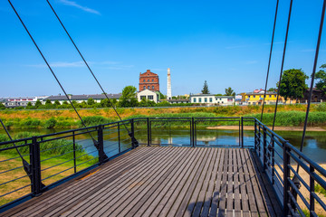 Panoramic view of the Warta river, the historic industrial buildings along the Nadbrzezna street and sightseeing platform in the historic quarter of Konin, Poland - obrazy, fototapety, plakaty