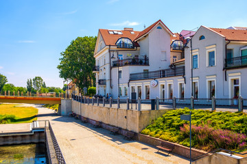 Promenade along the Warta river bank with Torunski bridge in the historic quarter of Konin, Poland - obrazy, fototapety, plakaty
