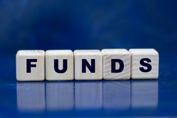 concept word funds on wooden cubes on a blue background
