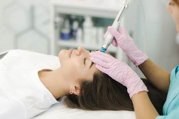 Close-up of woman getting facial hydro microdermabrasion peeling treatment. Female at cosmetic...