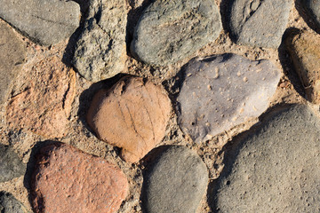Background of colored stones. The surface is decorated with natural material. Pattern on the floor of multicolored pebbles.