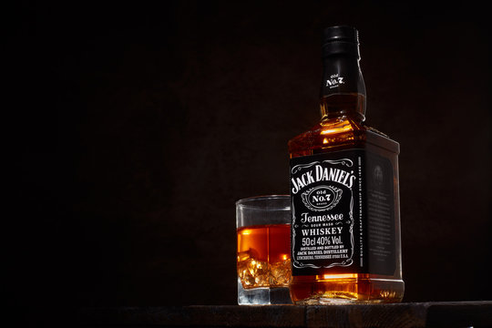 St.Petersburg, Russia - December 2019 - Bottle of Jack Daniel's whiskey and glass with drink and ice on brown background.